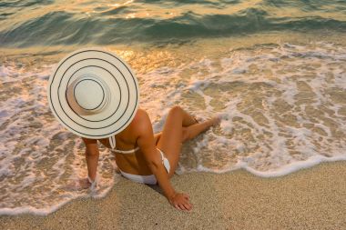 Plajda bikini ve saman şapkalı kadın