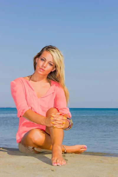 Mulher de camisa rosa na praia — Fotografia de Stock