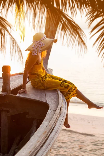 Woman on a long tail boat at sunset — Stock Photo, Image