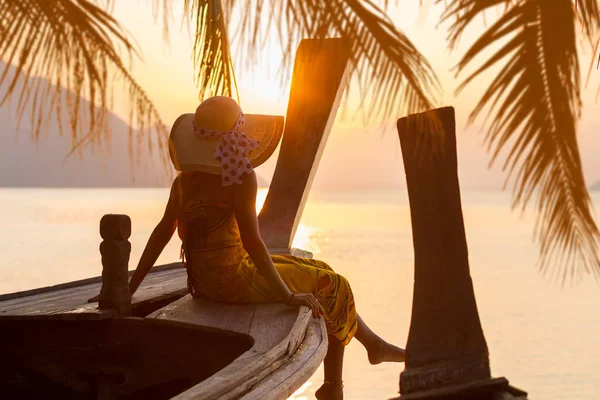 Woman on a long tail boat at sunset — Stock Photo, Image