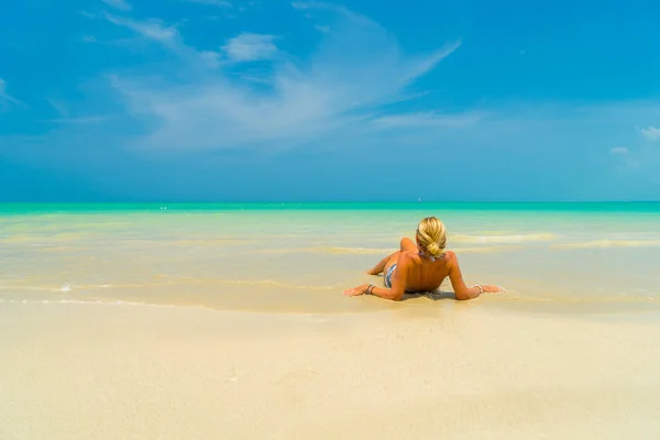 在美丽的热带海滩上的沙子上铺设的女人 — 图库照片