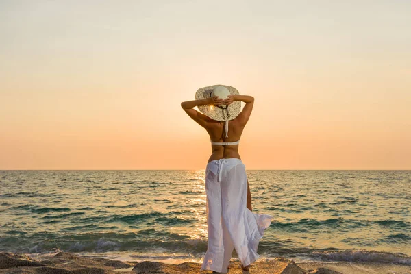 Γυναίκα καπέλο στην παραλία το ηλιοβασίλεμα — Φωτογραφία Αρχείου