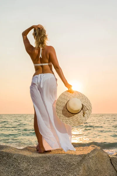 Vrouw hoed op het strand bij zonsondergang — Stockfoto