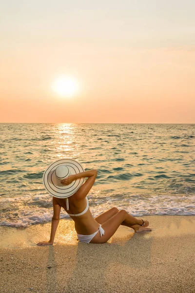 Kvinna i bikini och halm hat på stranden — Stockfoto