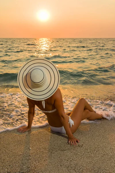 Femme en bikini et chapeau de paille sur la plage — Photo