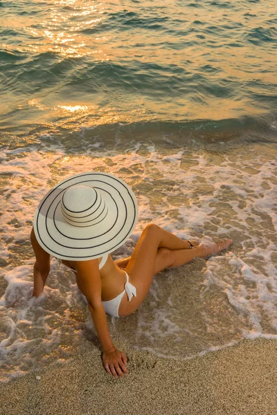 Plajda bikini ve saman şapkalı kadın