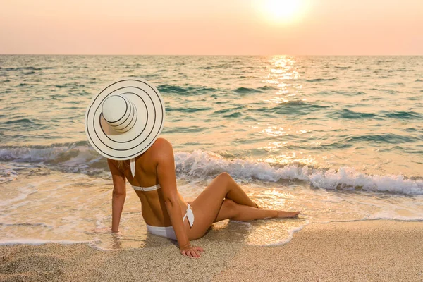 Žena v bikinách a straw hat na pláži — Stock fotografie