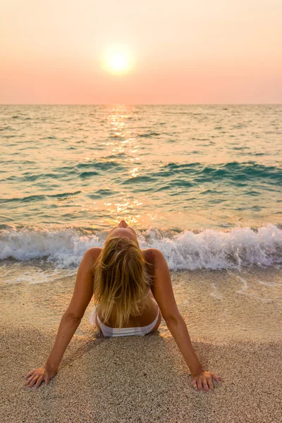 Vrouw in witte bikini op het strand — Stockfoto