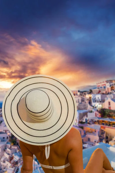 Mujer con sombrero viendo pueblo de Oia en la isla Santorini en Greec —  Fotos de Stock