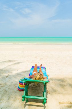 Plajda bir sandalyede oturan kadın
