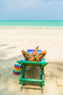 Plajda bir sandalyede oturan kadın