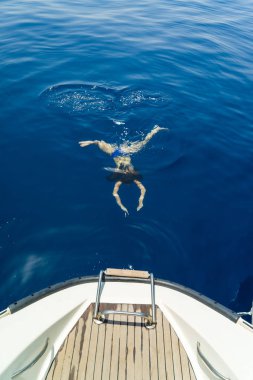 Genç kadın yelkenli tekne ile Yüzme 
