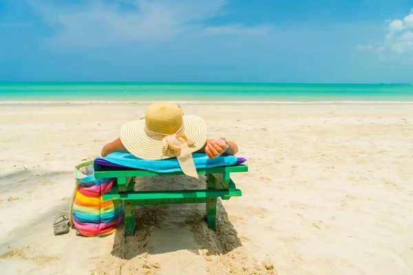 Kobieta siedzi na krześle na plaży — Zdjęcie stockowe