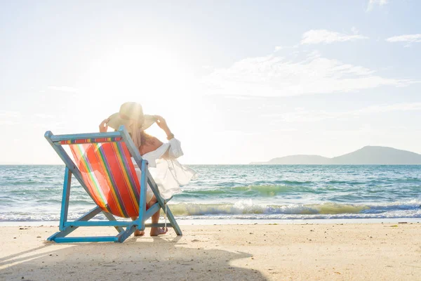 Жінка розслабляється на сонячному ліжку розкладний диван крісло у відпустці — стокове фото