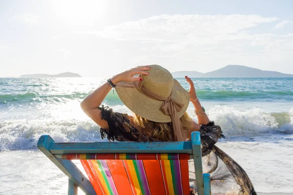 Mujer relajante en el sofá cama de sol silla de estar en vacaciones —  Fotos de Stock