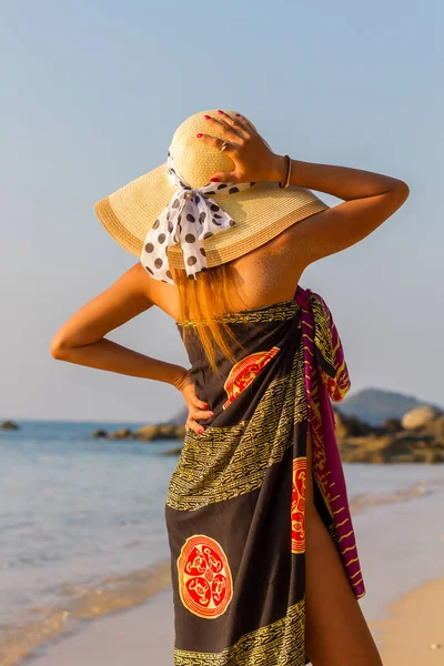 Mujer con sombrero en la playa al atardecer — Foto de Stock