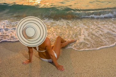 Plajda bikini ve saman şapkalı kadın
