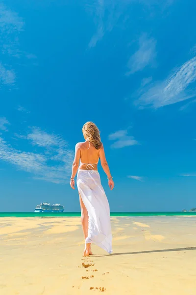 Frau geht am Strand spazieren — Stockfoto