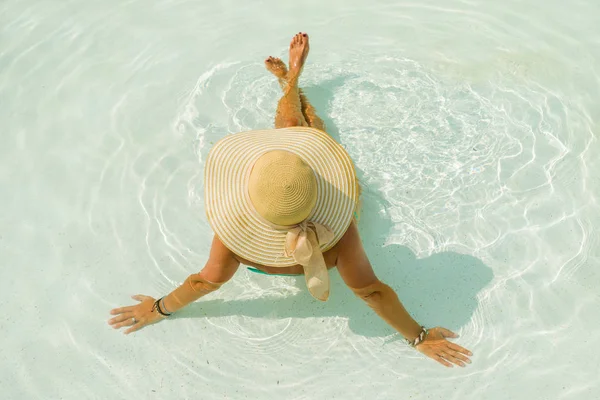 Vrouw met hoed bij het zwembad — Stockfoto