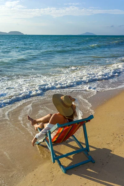 Жінка розслабляється на сонячному ліжку розкладний диван крісло у відпустці — стокове фото
