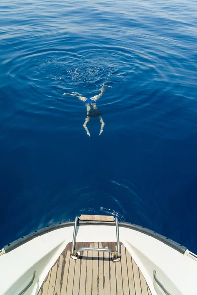 Young woman swimming by the sailing boat — Stock Photo, Image