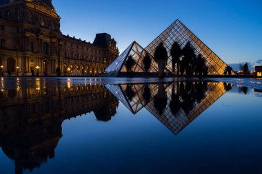 Paris, Fransa - 08 Aralık 2017: Ünlü Louvre Müzesi Louvre piramit akşam ile görünümünü. Louvre Müzesi dünya çapında en büyük ve en çok ziyaret edilen müzelerinden biridir