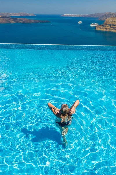 Kvinna njuta av avkoppling i pool och tittar på utsikten — Stockfoto