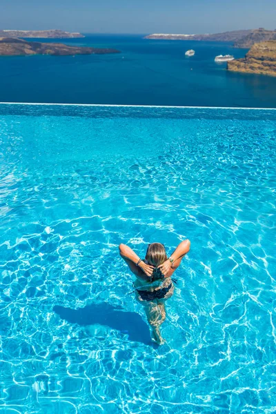 Kvinna njuta av avkoppling i pool och tittar på utsikten — Stockfoto