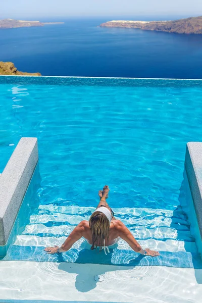 Kvinna njuta av avkoppling i pool och tittar på utsikten — Stockfoto