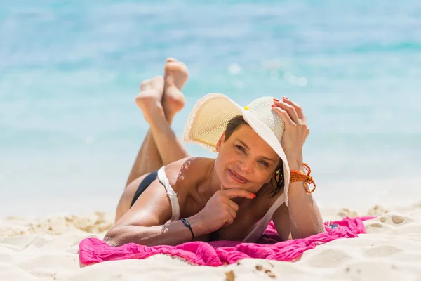 Mooie vrouw in stro hoed op het strand — Stockfoto