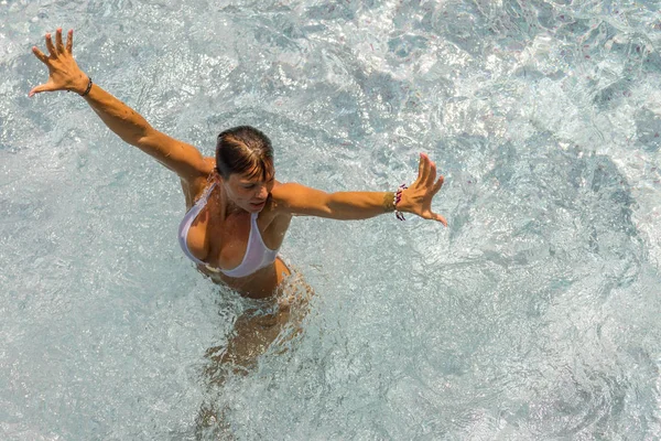 Молода жінка розслабляється в басейні — стокове фото