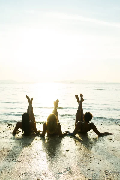 Silhouette de trois filles sur la plage au coucher du soleil — Photo