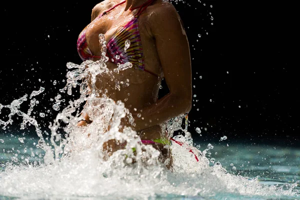 Junge schöne Frau macht Wasser planschen am Pool — Stockfoto