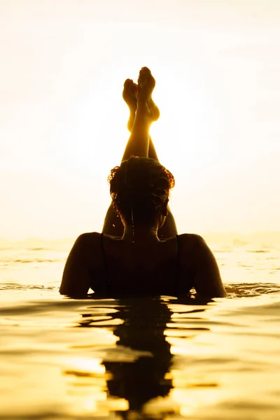 Силуэт молодой и здоровой женщины на пляже на закате — стоковое фото
