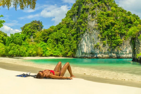 Young woman in bikini laying by the tropical sea — Stock Photo, Image