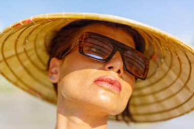 Sahilde traditionnal Vietnam şapkalı kadın