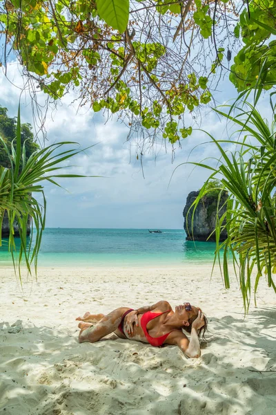 Young woman in bikini laying by the tropical sea — Stock Photo, Image
