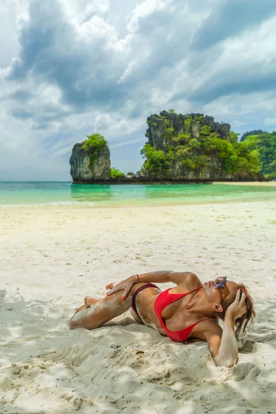 Junge Frau im Bikini am tropischen Meer liegend — Stockfoto