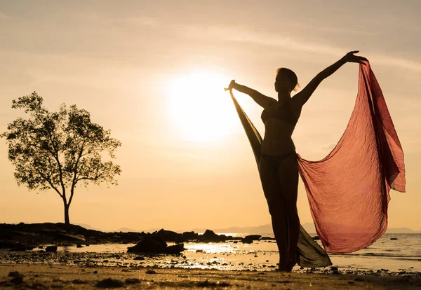 夕暮れ時にビーチで若い女性のシルエット — ストック写真