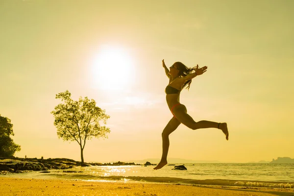Vrouw springen op het tropische strand in Thailand — Stockfoto