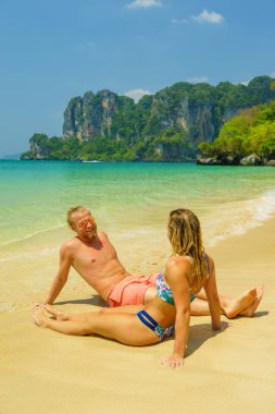 Plajdaki çift tropikal tatil beldesinde seyahat konsepti