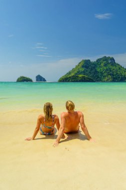 Plajdaki çift tropikal tatil beldesinde seyahat konsepti