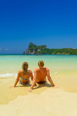 Plajdaki çift tropikal tatil beldesinde seyahat konsepti