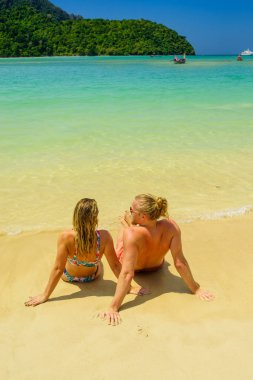 Plajdaki çift tropikal tatil beldesinde seyahat konsepti