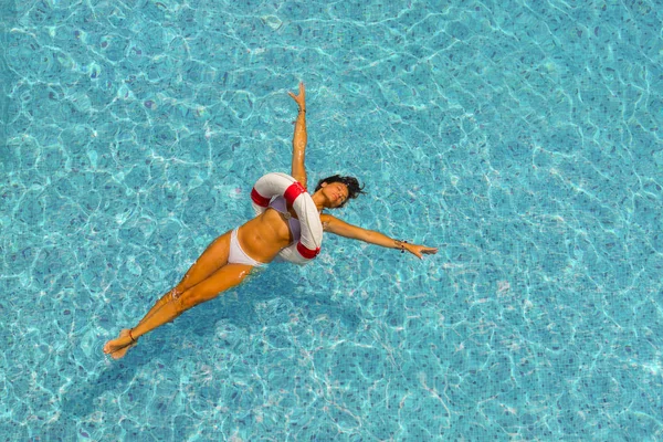 Mulher bronzeada bonita em roupa de banho azul relaxante no spa da piscina . — Fotografia de Stock