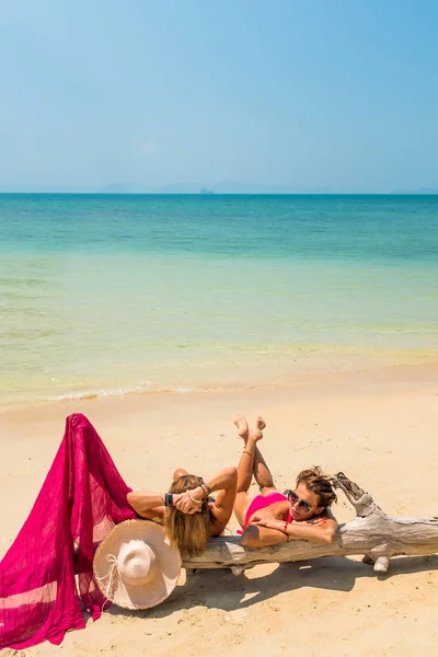 Två kvinnor sitter stranden av ett träd — Stockfoto