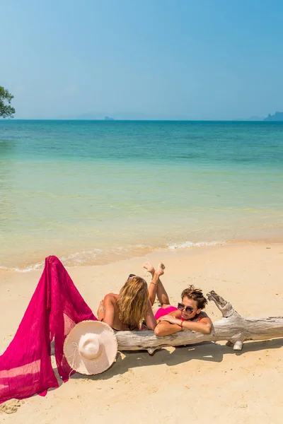 Två kvinnor sitter stranden av ett träd — Stockfoto