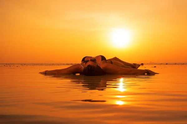 Silhouette einer jungen und fitten Frau am Strand bei Sonnenuntergang — Stockfoto