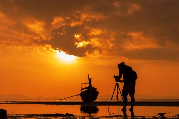 Silhuetten av en fotograf med stativ på vackra tropiska s — Stockfoto