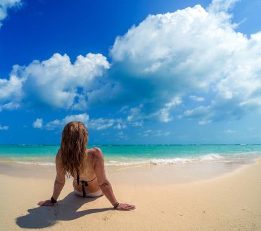 Kadın mavi wat ile tropikal bir plaj beyaz kum üzerinde döşeme